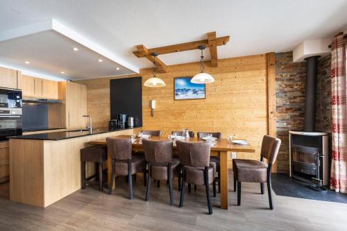 a kitchen and dining room with a table and chairs at Résidence Les Balcons de Val Thorens & Spa in Val Thorens