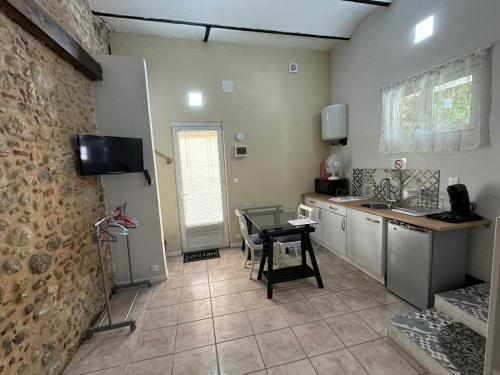 kuchnia ze stołem i umywalką w pokoju w obiekcie Studio à Le Boulou centre ville- pour 2 - petit prix- Juillet-aout réservation d'1 semaine minimum-check in 17-19h w mieście Le Boulou