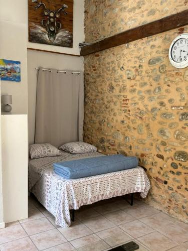 Cette chambre comprend 2 lits et un mur en pierre. dans l'établissement Studio à Le Boulou centre ville- pour 2 - petit prix- Juillet-aout réservation d'1 semaine minimum-check in 17-19h, au Boulou