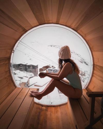 a woman is sitting in a round window at Résidence Les Balcons de Val Thorens & Spa in Val Thorens