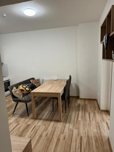a dining room with a wooden table and a couch at Apartmán v Jáchymově pro 4 osoby, free wifi in Jáchymov