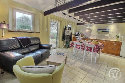 un salon avec un canapé en cuir et une cuisine dans l'établissement De kerloic, à Ploumilliau
