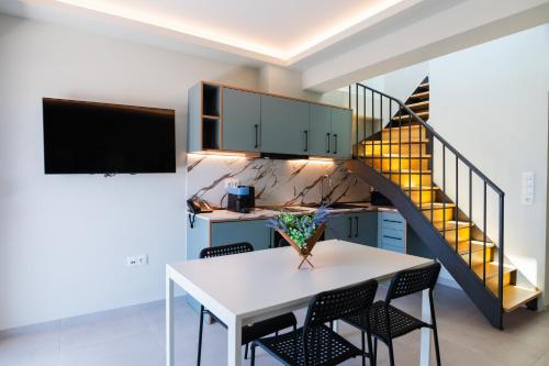 a kitchen with a white table and chairs and a staircase at Oktolia suites in Alexandroupoli