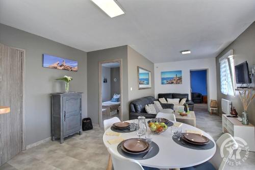a living room with a table and a couch at Les hortensias in Louannec