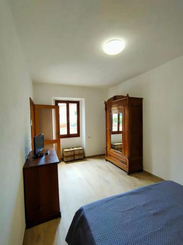 a bedroom with a bed and a cabinet and a television at chicca in nature near florence in Pratolino