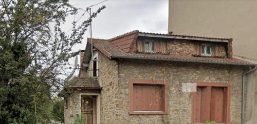 une vieille maison en briques avec des portes rouges dans l'établissement Chambre avec balcon dans charmante maison prêt d' aéroport d'Orly et proche paris, à Villeneuve-le-Roi