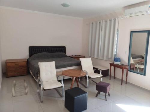 a bedroom with a bed and a table and chairs at Casa Águas de Lindoia com acesso ao Thermas in Águas de Lindóia