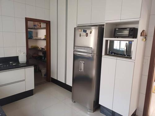 a kitchen with a stainless steel refrigerator and a microwave at Casa Águas de Lindoia com acesso ao Thermas in Águas de Lindóia