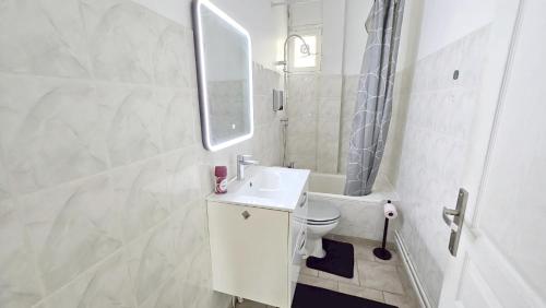 a white bathroom with a sink and a toilet at Appartement F2 Villeparisis in Villeparisis