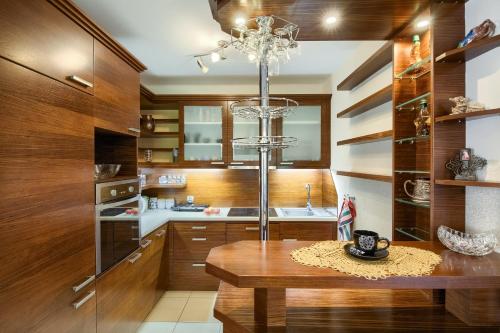 a kitchen with wooden cabinets and a table and a chandelier at Apartament U Jagody in Tylicz
