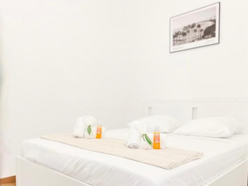 deux lits blancs avec des serviettes dessus dans l'établissement L’Iris - Suquet Cannes Centre, à Cannes