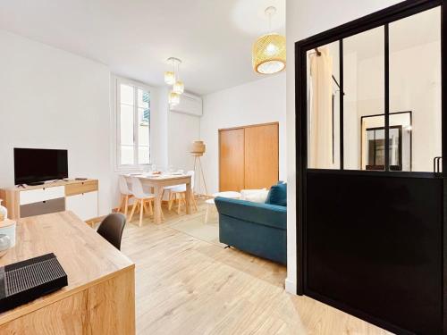 un salon avec un canapé bleu et une table dans l'établissement L’Iris - Suquet Cannes Centre, à Cannes