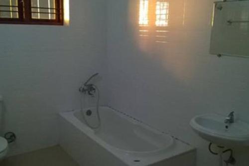 a white bathroom with a tub and a sink at Sea view beach view beautiful villa in Trivandrum