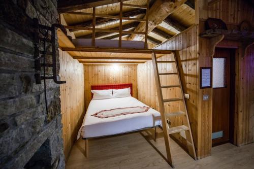 a bunk bed in a wooden room with a ladder at Rifugio Baita Belvedere in Champoluc