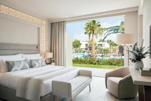 a bedroom with a large bed and a large window at Porto Sani in Sani Beach