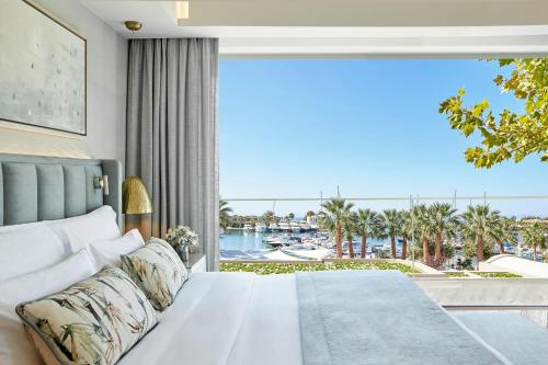 a bedroom with a bed and a large window at Porto Sani in Sani Beach