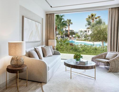 a living room with a couch and a large window at Porto Sani in Sani Beach