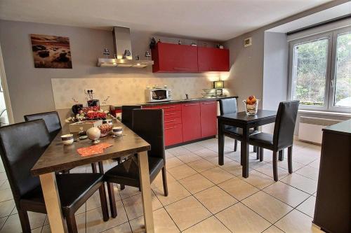 une cuisine avec des armoires rouges et une table et des chaises dans l'établissement Ti ma zud kozh, à Gommenec'h