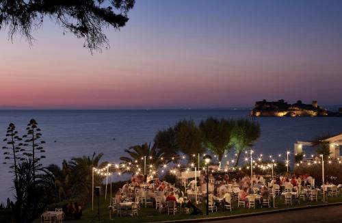 a group of people sitting in chairs at a restaurant at night at Sani Club in Sani Beach