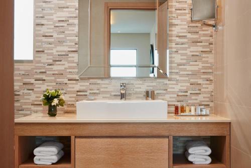 a bathroom with a sink and a mirror at Ikos Olivia in Gerakini