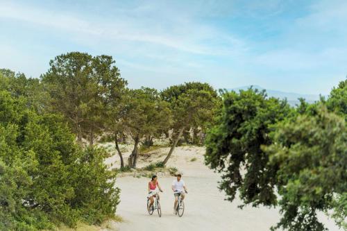 two people riding bikes on the beach at Ikos Aria in Kefalos