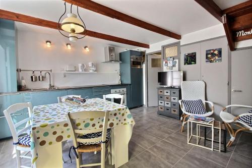 une cuisine avec une table et des chaises dans une pièce dans l'établissement Ty bretania, à Gicquel