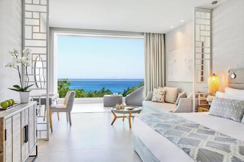 a bedroom with a view of the ocean at Ikos Aria in Kefalos