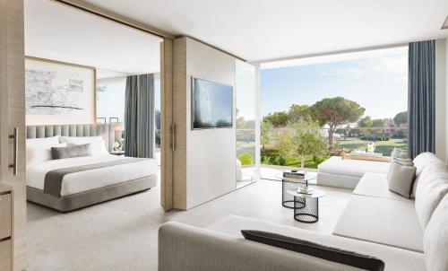 a bedroom with a bed and a living room with a couch at Ikos Andalusia in Estepona