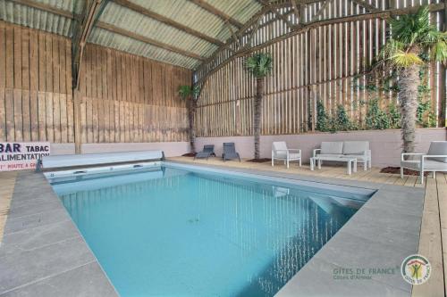 - une grande piscine dans un grand bâtiment avec des chaises dans l'établissement La motte, à Plourhan