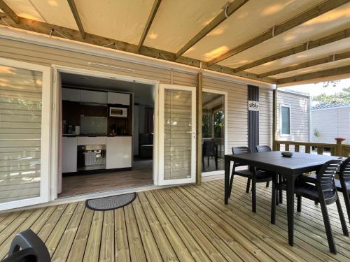 un patio avec une table et des chaises sur une terrasse dans l'établissement Mobil home sur le bassin d'Arcachon, à Lège-Cap-Ferret