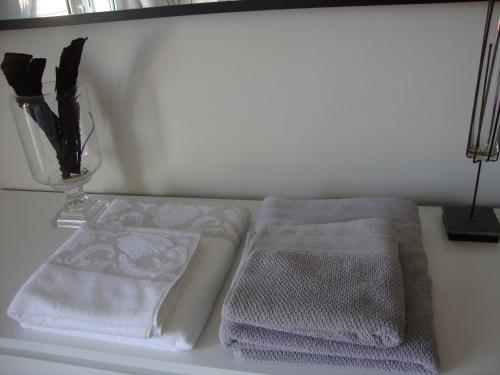 a table with two towels and a vase on it at Casa Italia Hospitality in Lunghezza