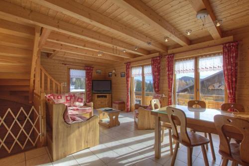 - une salle à manger et un salon dans une cabane en rondins dans l'établissement Chalet Makaau - Praz de Lys, à Taninges