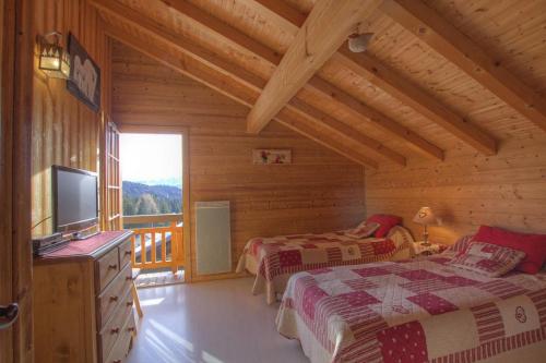 una camera con due letti e una televisione in una cabina di Chalet Makaau - Praz de Lys a Taninges