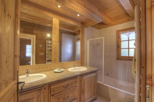 un bagno con due lavandini e un grande specchio di Chalet Makaau - Praz de Lys a Taninges