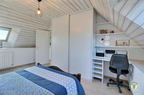 a bedroom with a bed and a desk and a chair at La clef des champs in Kérien