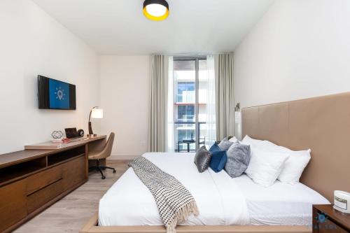 Un dormitorio con una cama y un escritorio con una computadora. en Rooftop Pool Balcony Hollywood Beach Broad walk, en Hollywood