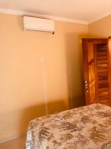 a bedroom with a bed and a air conditioner on the wall at Sítio Vovô Erasmo in Itarema