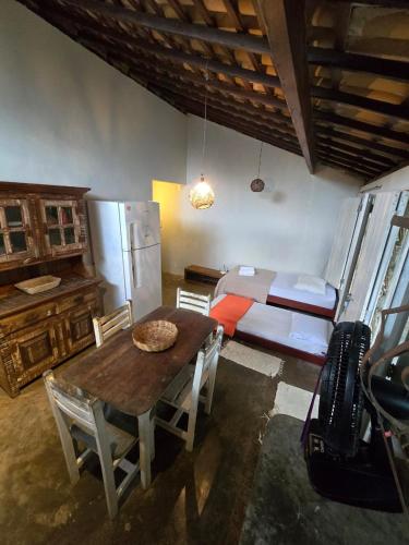 a kitchen with a table and a refrigerator and a bed at Stay Cool Pipa in Pipa
