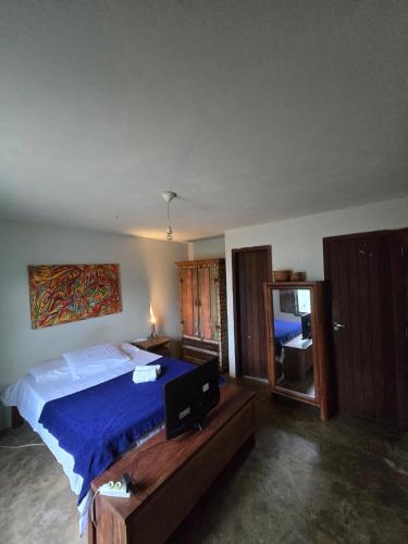 a bedroom with a large bed with a blue blanket at Stay Cool Pipa in Pipa
