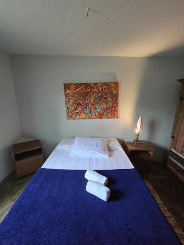 a bedroom with a blue bed with towels on it at Stay Cool Pipa in Pipa