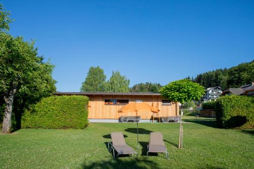 a yard with two chairs and an umbrella at Ferienwohnungen Gabriel in Keutschach am See