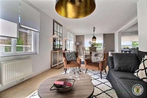 un salon avec un canapé et une table dans l'établissement Sous le cerisier, à Créhen