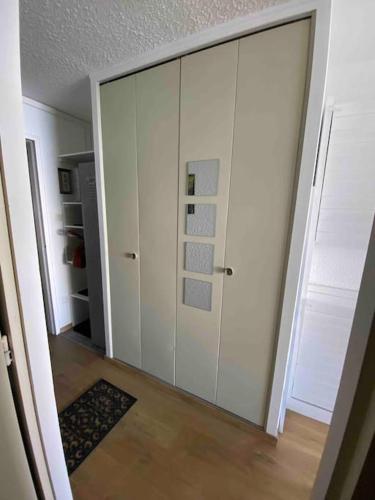 Cette chambre comprend une grande armoire blanche. dans l'établissement Studio rénové, pied des pistes, à Allevard