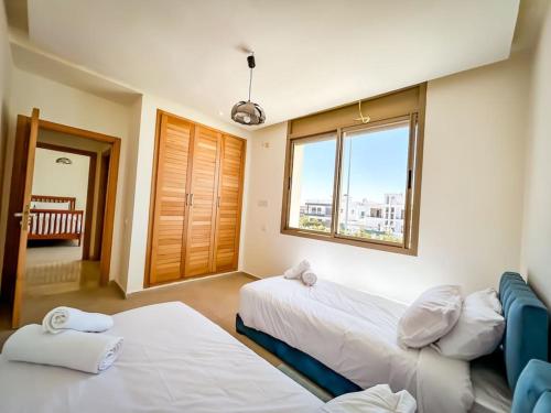 a hotel room with two beds and a window at Villa de luxe résidence front de mer 50m de la mer in Tamaris