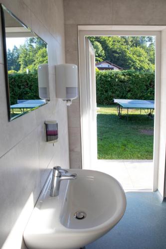a bathroom sink with a mirror and a table outside at Ferienwohnungen Gabriel in Keutschach am See