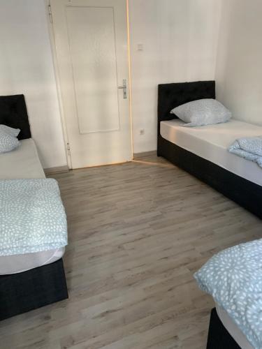 two beds in a room with a wooden floor at Unterkunft Mara in Oberhausen