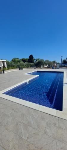 a swimming pool with blue water in a courtyard at SEA HOUSE mobile home, pool, bikes, SUP - PRIVILEGE POINT camping & villas in Orebić