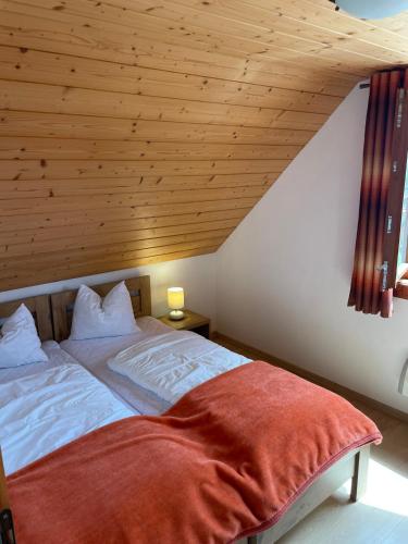 a bedroom with a bed with a wooden ceiling at Chata s výhľadom na Tatry in Hrabušice