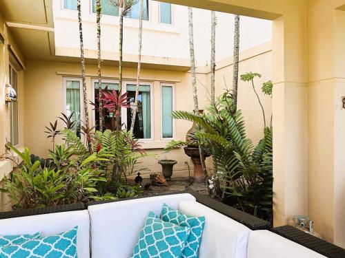 a porch with a white couch and some plants at Villa De Palma -Oceanfront community w generator in Sabana