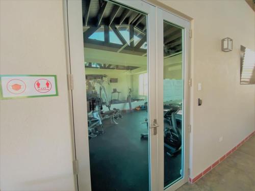 an open door to a gym with treadmills at Villa De Palma -Oceanfront community w generator in Sabana